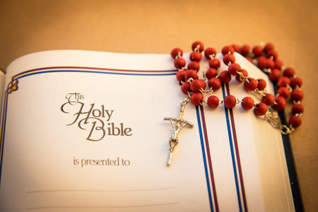 wooden rosary with a crucifix on the Bible 