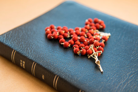 A wooden rosary in the form of a heart on the Bible