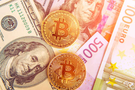 Two bitcoins on denominated dollars and euro (Investment, course change - concept)の写真素材