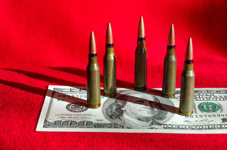 Bullets and banknotes on a black background as an abstract example of the causes of military conflicts in the worldの写真素材