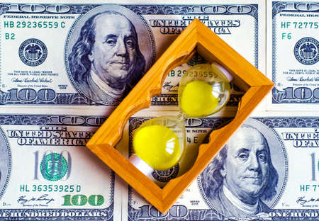 The hourglass is in dollars as a symbol of capital creation by its own workの写真素材