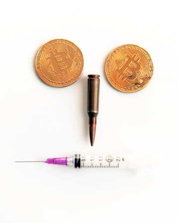 Bitcoins, a syringe, a bullet and a cocaine as a symbol of crimes that can hide crypto-currency (a stylized portrait of a criminal and a terrorist is a concept)の写真素材