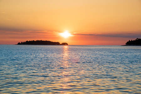 Incredibly beautiful romantic landscape with sunset at sea between the islands (vacation, rest, harmony, meditation, honeymoon - concept)の写真素材