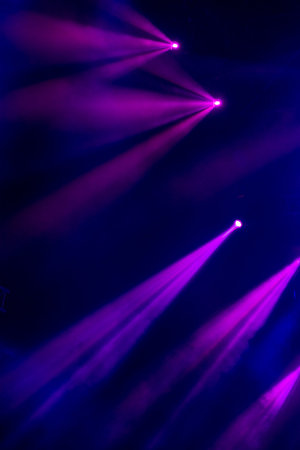 abstract magic image with rays of colored light from the spotlights in the dark