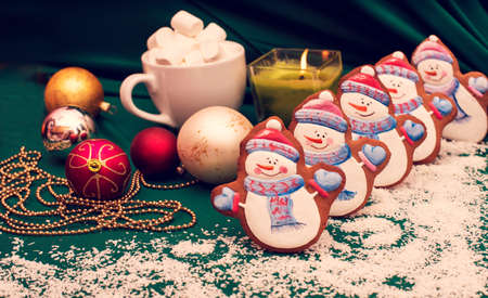 Congratulatory background with christmas-world cookies in the form of snowmen as a symbol of the new year 2019 with New Year's toys and a candle (greeting card, greetings - concept)の写真素材