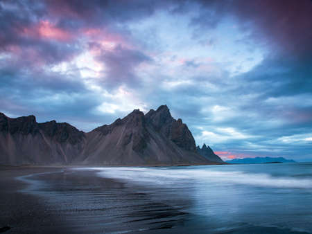 Scenic landscape with most breathtaking mountains Vestrahorn on the Stokksnes peninsula with the waves of the bay at sunset in Iceland. Exotic countries. Amazing places.の写真素材