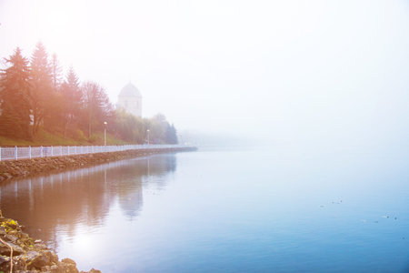 mystical landscape with the old church above the lake in the misty morning in Ternopil, Ukraineの写真素材