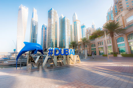Dubai, United Arab Emirates â February 13, 2021: The inscription Dubai Marina on the waterfront of the eponymous picturesque residential area in the largest city of the United Arab Emirates against the backdrop of skyscrapers.のeditorial素材