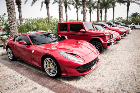 Dubai, United Arab Emirates â February 10, 2021: A red Ferrari car next to other luxurious stylish modern cars parked near the hotel in Dubai.のeditorial素材