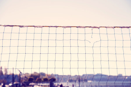 Torn volleyball net on the background of the city (failure, loss, breakdown - concept)の写真素材
