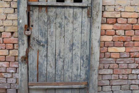 Decrepit and old door and brick wall in the eveningの写真素材