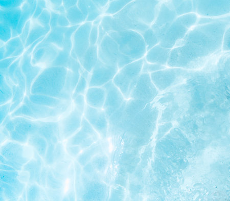 Blue water in swimming pool with sun reflection. Abstract background and texture for designの写真素材