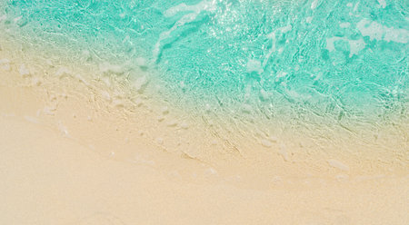 Blue sea wave on sandy beach background. Top view with copy space