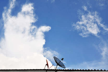 satellite dishes on a house roofの写真素材