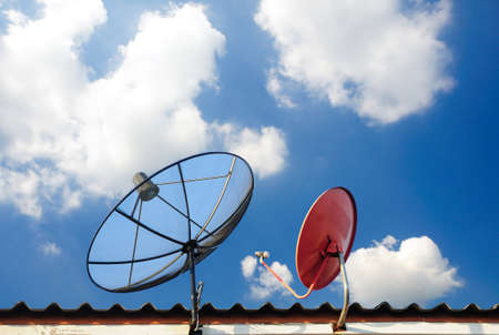 satellite dishes on a house roofの写真素材