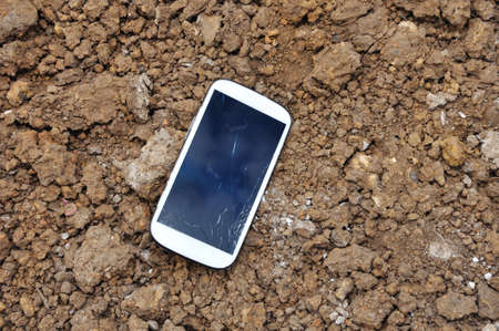 White Cell phone On Soil Surface.の写真素材