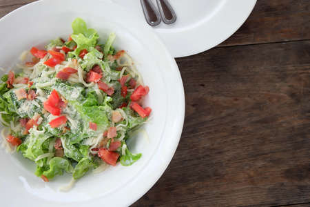 Tuna salad on white dish and wooden floor.の写真素材