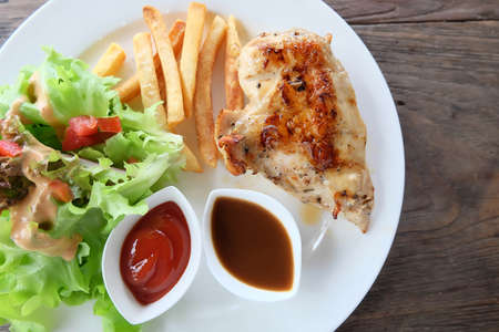 chicken steak on white dish and wooden floor.の写真素材