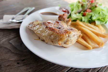 chicken steak on white dish and wooden floor.の写真素材