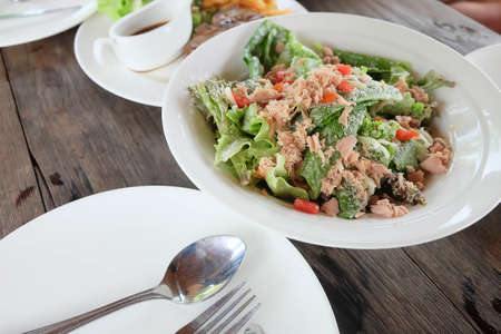 Tuna salad on white dish and wooden floor.の写真素材