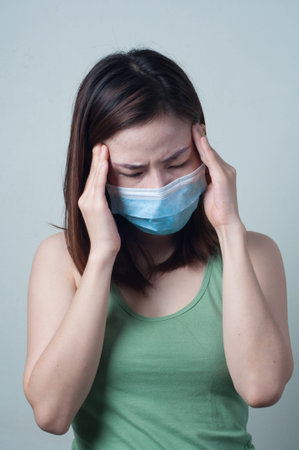Asian Beauty Women wear a mask are feeling headache.