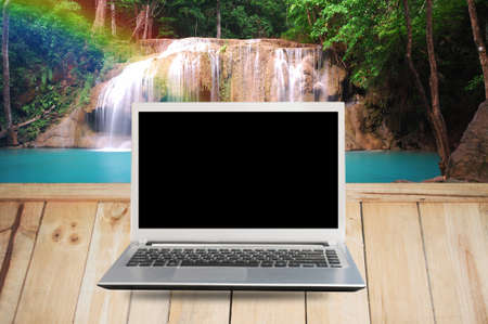 Laptop copy space on Wood floor and waterfall background.の写真素材