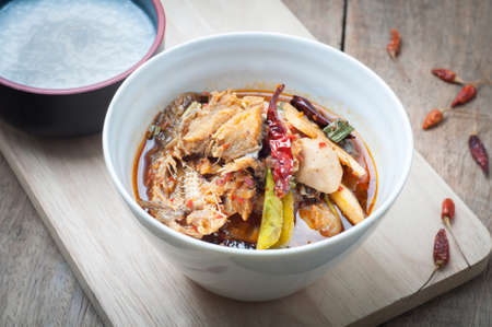 Sour and Spicy Smoked dried Fish Soup on and rice porridge wood floor, The national cuisine of Thailand.の写真素材