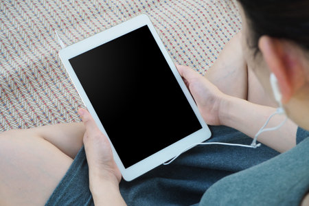 woman listening something from tablet device in relaxing concept, selected focus on device.