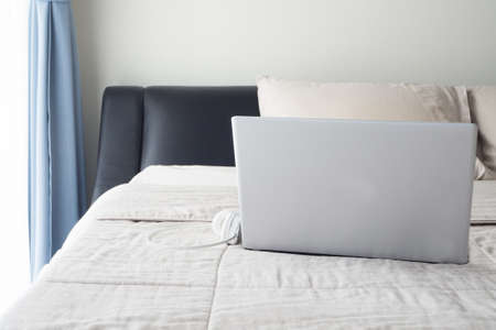 The bed with laptop  and earphone in bedroom.の写真素材