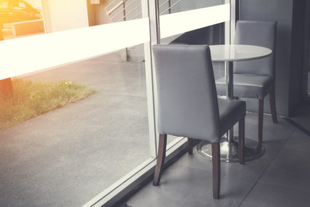 Cafe and luxury with sunny morning and two Chairs at the relax corner inside the coffee shop.