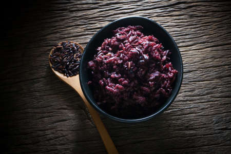 cooked black rice and grain of rice on kitchen table, Low key picture style.の写真素材