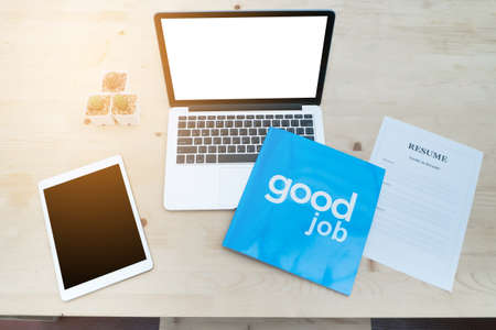 office table with blank screen of  laptop, tablet and resume information. concept of job searching.の写真素材