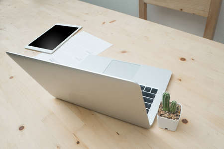 Wood Office table with modern laptop and cactus flower on white pot, concept of office equipment.の写真素材