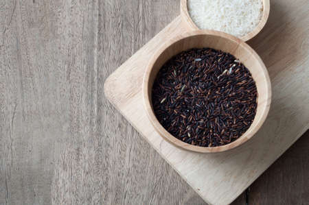 black grain of rice on wood table, selective focus on top view.の写真素材