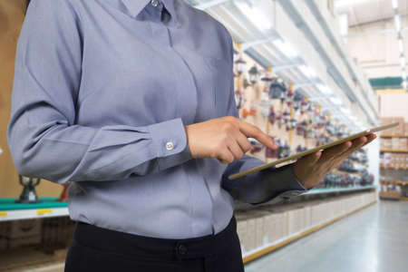 businessman hold and touch smartphone, tablet, cell phone on blurry lamp shop store, concept of shopping interior decoration.の写真素材