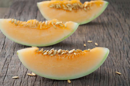 slice fresh cantaloupe melon on cutting board, freshness yellow fruit on kitchen table. healthy eating and dieting food, concept of health care, Image focus top view.の写真素材
