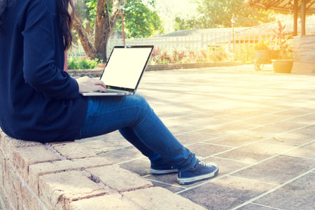 business people typing on laptop with blank screen at park, concept of Asian businessman lifestyle,...
