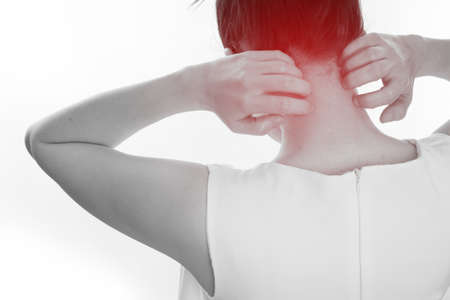 young woman scratching neck on isolated white background. concept of health care lifestyle. view from back body.の写真素材