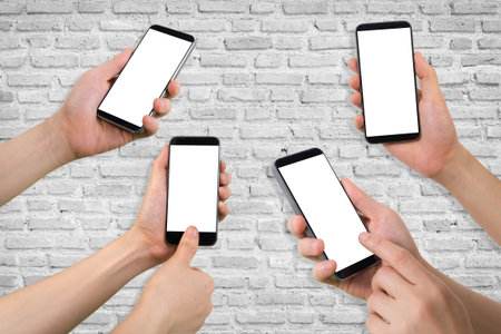 group of human hand hold ,smartphone, tablet, cell phone on white brick wall texture background.