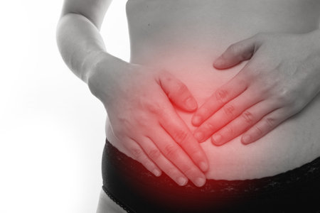 close up woman hand patting stomach on isolated white background.