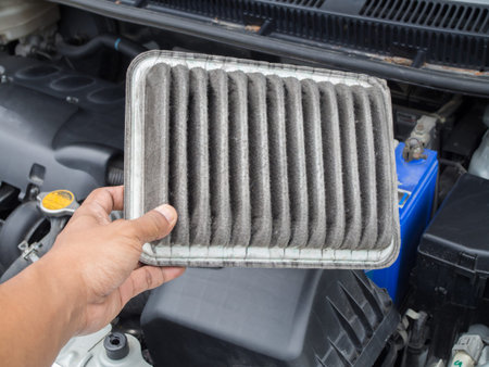 human hand hold dirty air filter in car, concept of cleaning and checking air filter.