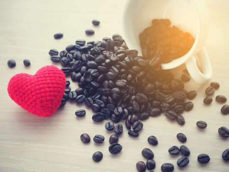 close up of fresh coffee bean and red heart shape sign, warm tone.の写真素材