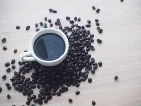 wood table with black coffee cup and coffee bean, view from top wood table.の写真素材