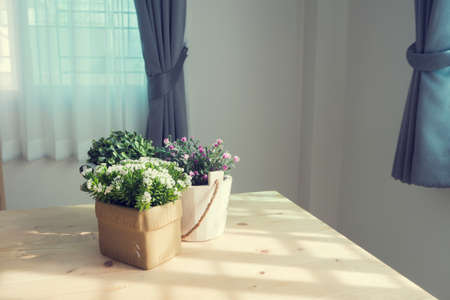wood table with group of beautiful artificial flower on pot at living room.の写真素材