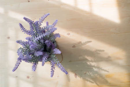 wood table with  purple lavender artificial flower on pot at living room. view from top wood table.の写真素材