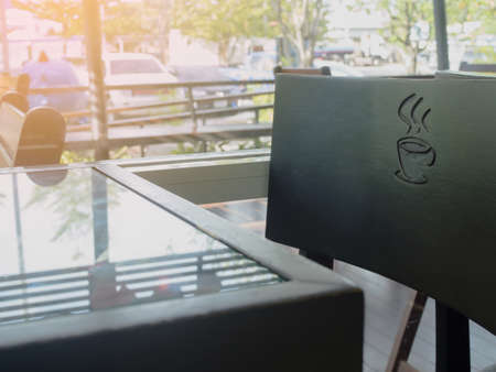 glasses table with black chair with coffee cup sign at coffee shop.の写真素材