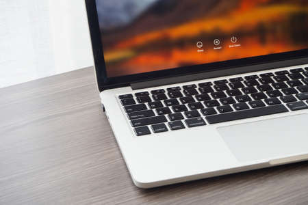 CHONBURI,THAILAND - NOV 12,2017 : Office table with Macbook Pro retina 13 inch with macOS High Sierra Screen with Sleep, Restart, Shut down icons.のeditorial素材