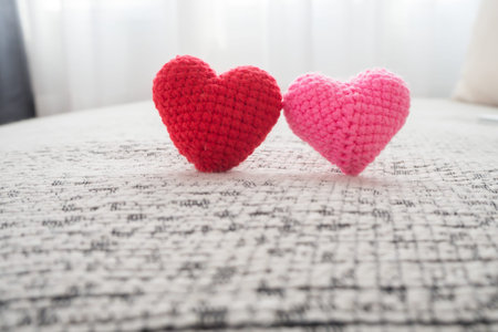 Beautiful couple knitted fabric heart shape on fabric texture on white curtain windows background...