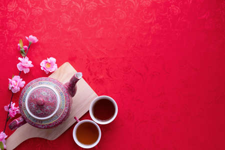 teapot and cup of tea with Copy space for text on red texture background, Chinese new year background.の写真素材