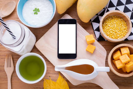 wood table with Blank screen on smart phone, tablet, cell phone  with breakfast.の写真素材